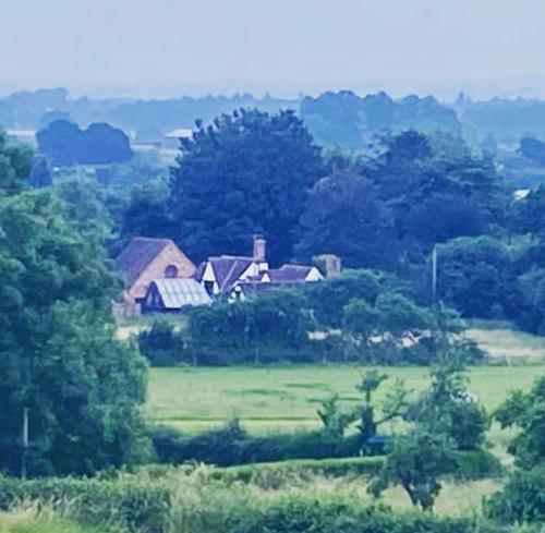 a group of houses in a field with trees at Private Loft Country Hideaway in Shifnal