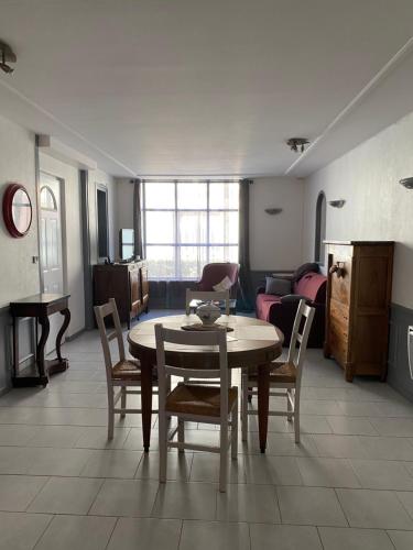 - un salon avec une table, des chaises et un canapé dans l'établissement L’orthographe, à Villers-Cotterêts