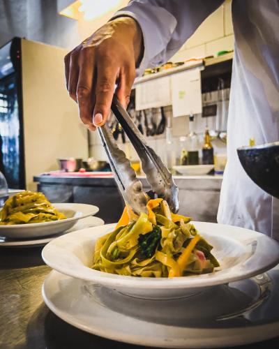 a chef cutting a plate of food with a fork and knife at El Albergue Ollantaytambo in Ollantaytambo