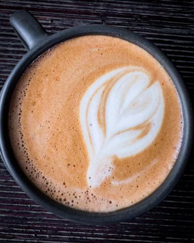 a cup of cappuccino with a swirl in it at El Albergue Ollantaytambo in Ollantaytambo
