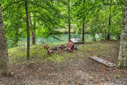 a picnic table and two chairs in the woods at Deer Haven Cabin 5 Mi to Dtwn Blue Ridge! in Blue Ridge