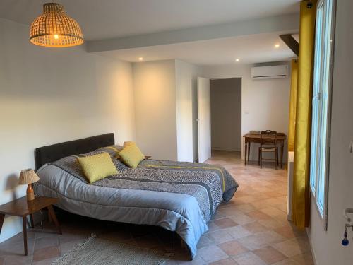 a bedroom with a large bed with yellow pillows at Petite maison in Gabarret
