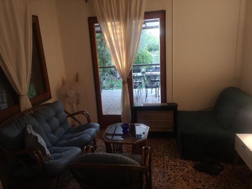 a living room with a couch and a window at Bamboo gardens in Nea Irakleia