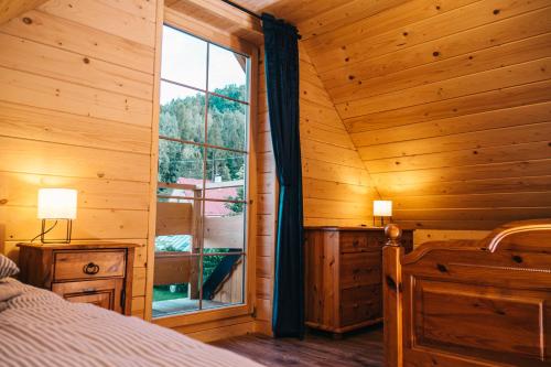 a bedroom with a large window in a log cabin at Chabrowa Chatka in Ustroń
