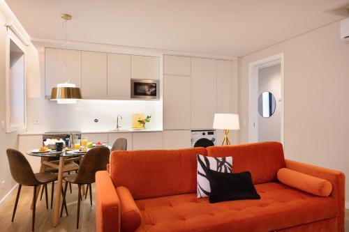un soggiorno con divano arancione e tavolo di Byobu Apartment, by Bolhão Residences a Porto