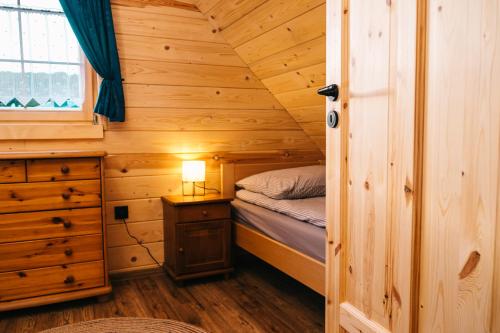 a bedroom with a bed in a wooden cabin at Chabrowa Chatka in Ustroń