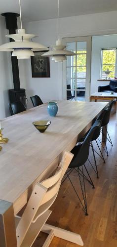 duży drewniany stół w pokoju z krzesłami w obiekcie Privat Villa w mieście Skive