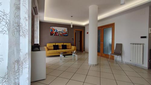 salon z żółtą kanapą i stołem w obiekcie NickyHouse Holiday Home w mieście Giffoni Sei Casali