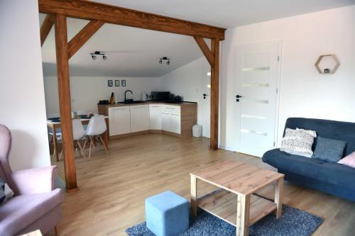 salon z niebieską kanapą i stołem w obiekcie Apartament Tamaryszek w mieście Sandomierz