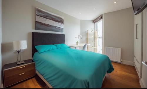 a bedroom with a large bed with a blue blanket at Fantastic 3 bedrooms flat in Euston Zone 1 in London