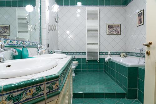 ein Badezimmer mit zwei Waschbecken und einer Badewanne und einer Toilette in der Unterkunft My Place Apartment in Castellammare di Stabia