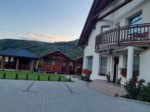 a building with a patio and a balcony on it at Kincses Panzió in Praid
