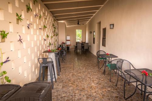 a room with tables and chairs and a wall with plants at Azcapri Villa Boutique & Spa in Cancún