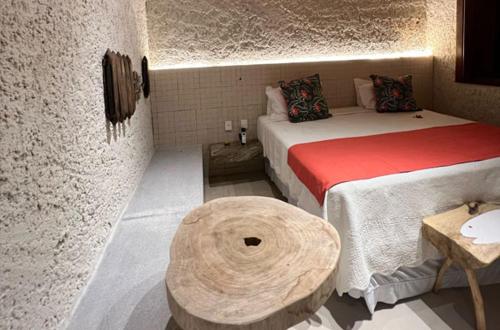 a small room with a bed and a table at Villas Taturé in São Miguel dos Milagres