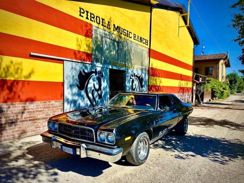an old muscle car parked in front of a building at Pirola Music Ranch Guest House B&B in Romano di Lombardia