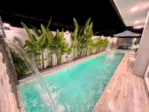 a swimming pool with a water fountain at April Pool Villa Airport in Chiang Mai