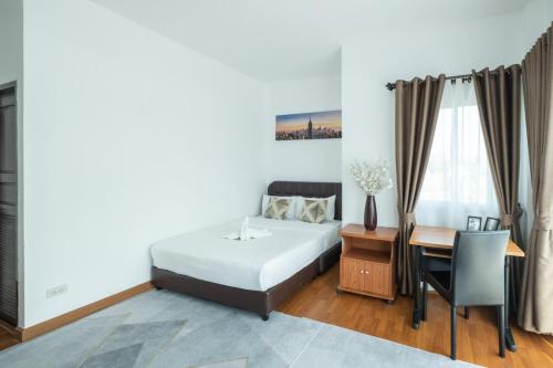 a bedroom with a bed and a desk and a table at April Pool Villa Airport in Chiang Mai