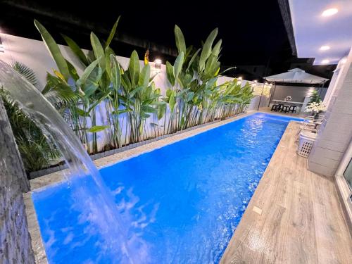 a swimming pool in a backyard with a water fountain at April Pool Villa Airport in Chiang Mai