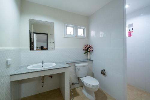 a white bathroom with a toilet and a sink at April Pool Villa Airport in Chiang Mai