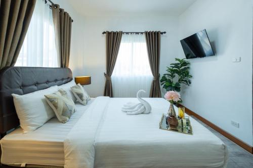 a bedroom with a large bed with a television at April Pool Villa Airport in Chiang Mai