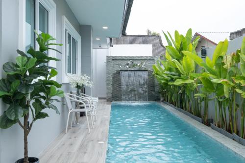 a swimming pool in the middle of a building with plants at April Pool Villa Airport in Chiang Mai
