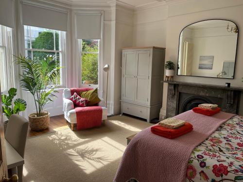 a bedroom with a bed and a fireplace and a mirror at Elegant Bloomsbury Apartment in Tunbridge Wells in Royal Tunbridge Wells