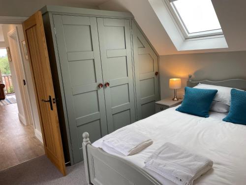 a bedroom with a large white bed with blue pillows at Coach House Mews in Stratford-upon-Avon
