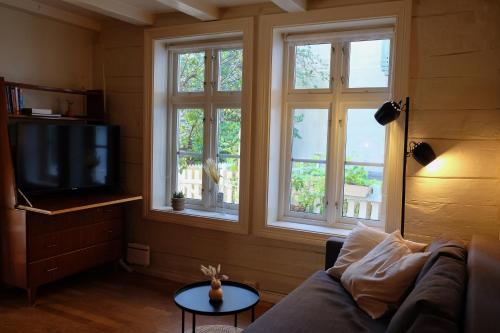 un soggiorno con divano e 3 finestre di Charming Bergen house, rare historic house from 1779, Whole house a Bergen