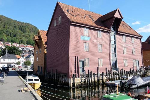 a large red building sitting next to a marina at Charming Bergen house, rare historic house from 1779, Whole house in Bergen