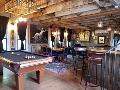 uma sala de bilhar com uma mesa de bilhar e um bar em Cedar Oaks Inn The Birdcage Saloon em Dickinson