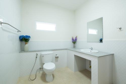 a white bathroom with a toilet and a sink at April Pool Villa Airport in Chiang Mai