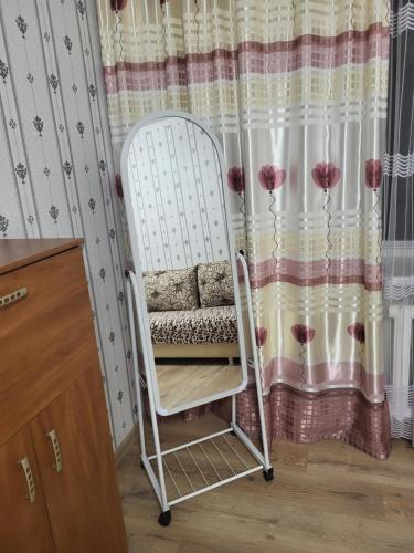 a white rocking chair in front of a curtain at Центр города. in Almaty