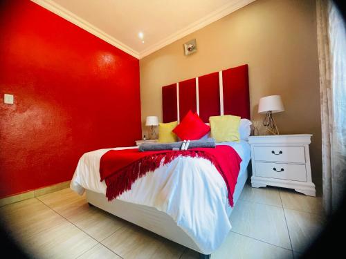 a red bedroom with a bed and a red wall at The Grace Villa Guesthouse in Nelspruit