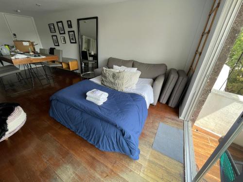 a bedroom with a bed with a blue blanket at CHIC Full Condo @ - Heart of Roma, downtown CDMX in Mexico City