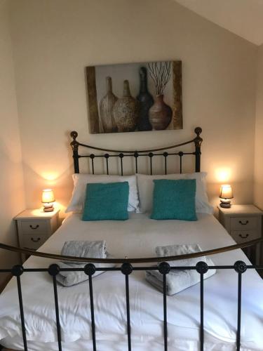 Heussé的住宿－La Perruche Holiday Gite，一间卧室配有一张带蓝色枕头的床和两盏灯。