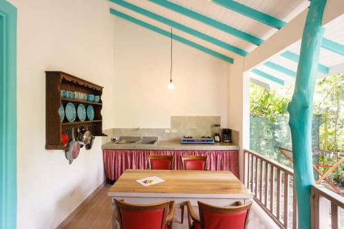 プエルト・ビエホにあるVilla Casa Azul & Arena Blanca Apartamentosのキッチン(木製テーブル、赤い椅子付)