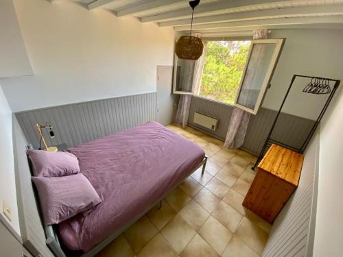 sypialnia z fioletowym łóżkiem i oknem w obiekcie Belle et grande villa pour des séjours en famille et entre amis w mieście Cruscades