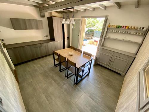 une cuisine avec une table et des chaises dans une pièce dans l'établissement Belle et grande villa pour des séjours en famille et entre amis, à Cruscades