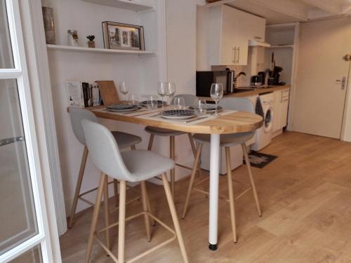- une cuisine avec une table, des chaises et des verres à vin dans l'établissement Studio mezzanine hyper centre, au pied du castillet, à Perpignan