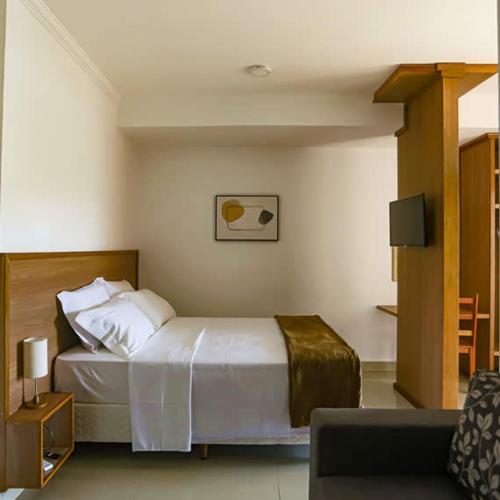 a hotel room with a bed and a couch at Bliss Hotel Vale do Café in Vassouras