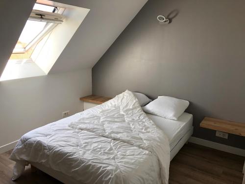 a bedroom with a white bed with a window at Appartement 3 Étoiles - Plage des Phoques avec Parking Privé in Berck-sur-Mer