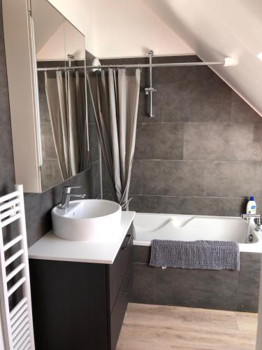 a bathroom with a sink and a bath tub at Appartement 3 Étoiles - Plage des Phoques avec Parking Privé in Berck-sur-Mer