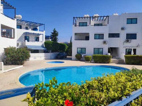 uma piscina em frente a um edifício em Marina Gardens em Pafos