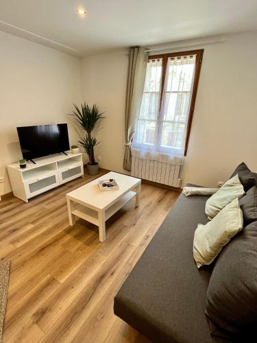 uma sala de estar com um sofá e uma mesa em La Pause Cosy em Champagne-sur-Oise