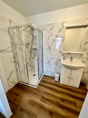 a bathroom with a shower and a sink at La Pause Cosy in Champagne-sur-Oise