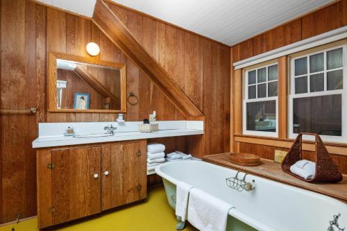 a bathroom with a tub and two sinks at Gin Ridge Cottage in Gearhart