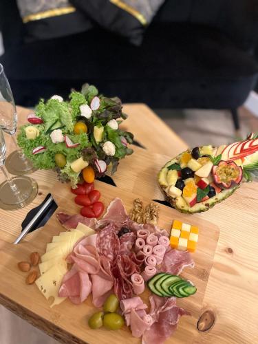 una tabla de cortar de madera con diferentes tipos de comida. en La Pause Cosy, en Champagne-sur-Oise