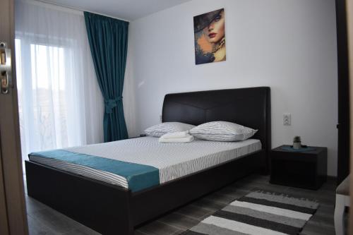 a bedroom with a bed with a black headboard at Casa Dumitru 2 in Valea Borului