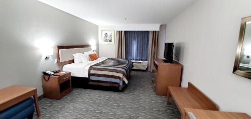 a hotel room with a bed and a television at Spark By Hilton Tupelo in Tupelo