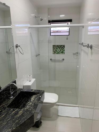 a bathroom with a shower and a toilet and a sink at Prudentópolis Palace Hotel in Prudentópolis